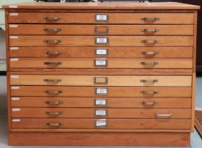 A 20th century pine plan chest with ten shallow drawers with brass drawer pulls flanked by