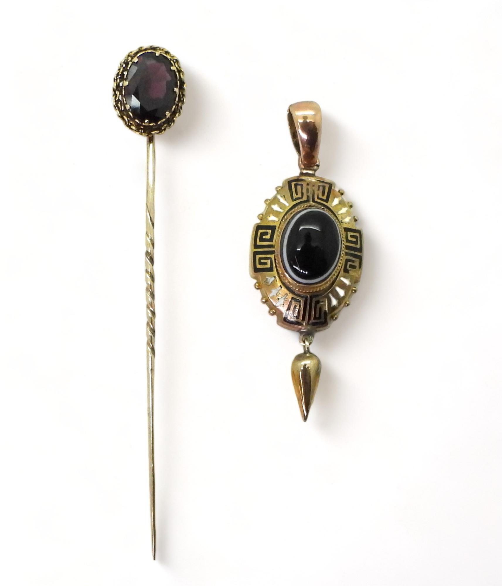 A Victorian yellow metal pendant set with a Bull's eye agate, with black and white Greek key and bud