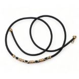 A rubber necklet with 14ct gold clasp and 14ct rose and white gold beaded detail, weight 8.2gms