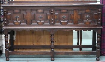 A 20th century oak Jacobean style two drawer buffet table on turned supports joined by stretchers,