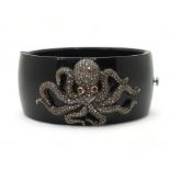 An octopus bangle, the white and yellow metal octopus, is completely pave set with brilliant cut