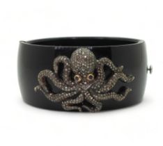 An octopus bangle, the white and yellow metal octopus, is completely pave set with brilliant cut