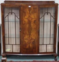 An early 20th century mahogany bow front glazed display cabinet on ball and claw feet, 130cm high