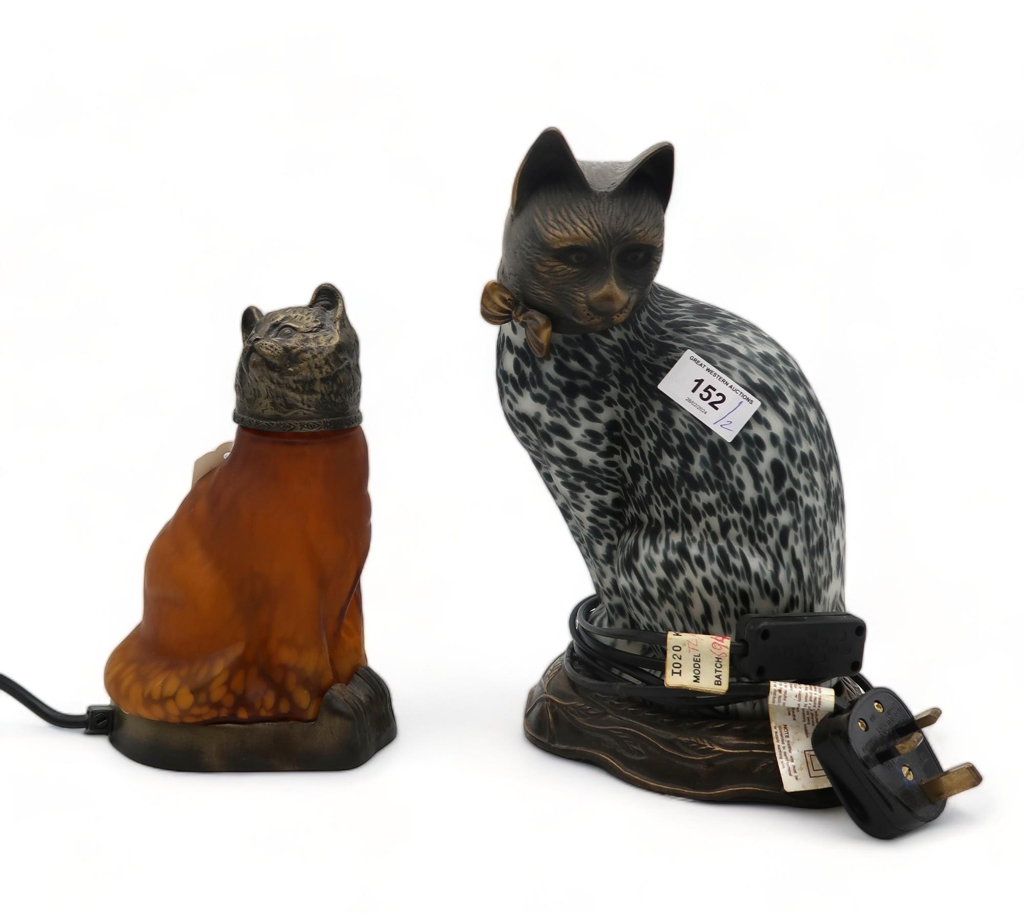 A glass and metal cat lamp with black and white mottled effect and another in amber glass