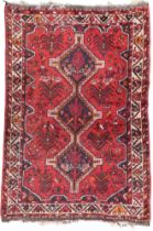 A red ground Shiraz rug with three geometric medallions and multicoloured geometric border, 156cm