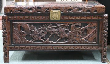 A 20th century Oriental camphor wood blanket chest extensively carved with battle scenes on carved
