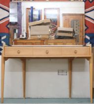 A mid 20th century beech with mirrored back and worksurface over three drawers on turned tapering