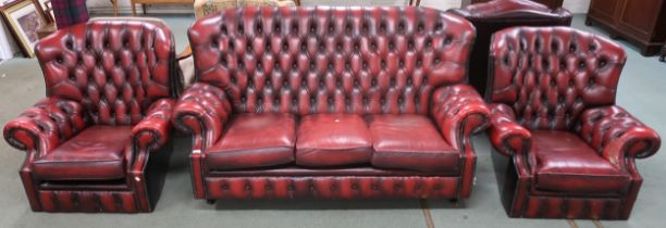 A 20th century oxblood leather buttonback upholstered Chesterfield style three piece suite