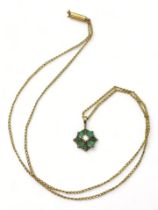 A yellow metal emerald and diamond flower pendant on a 9ct gold Ciro fine curb chain, length 40cm,