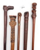 Five Folk Art carved walking sticks, comprising two with pommels formed as male heads (one with