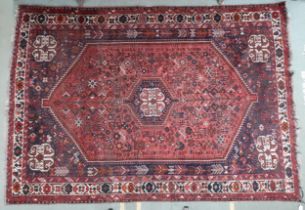 A lot comprising a red ground Abadeh rug with dark blue central medallion, matching spandrels and