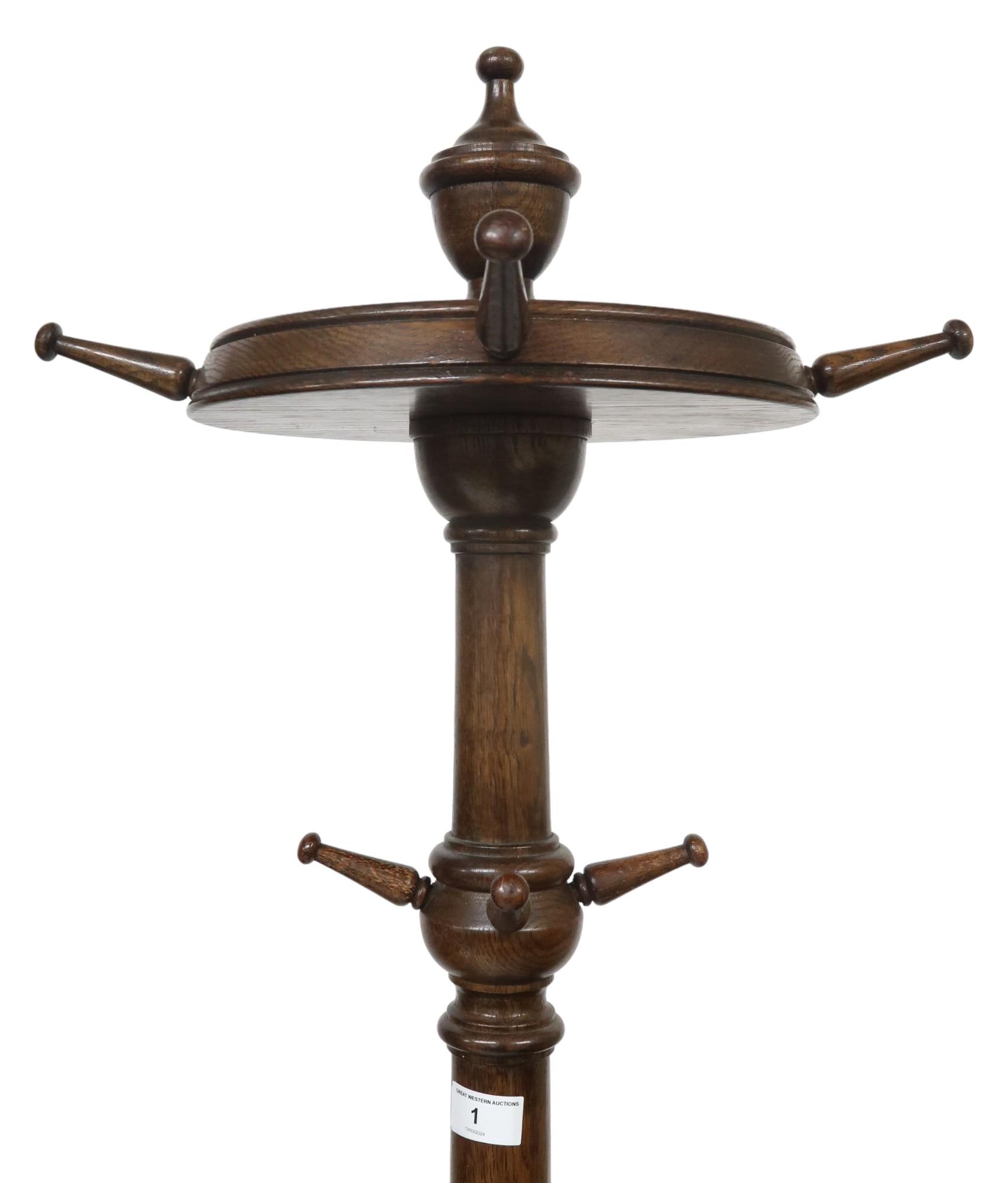 An early 20th century stained oak coat stand with turned finial top over four revolving pegs (one - Image 2 of 4