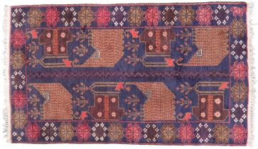 A dark blue ground Persian rug with geometric patterned ground and multicoloured flower head border,