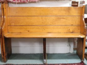 An early 20th century pine church pew/settle with shaped ends and middle trestle support, 98cm