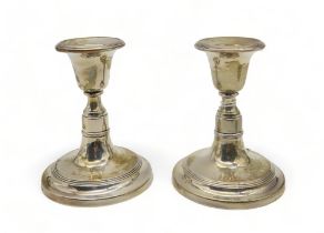 A pair of silver dwarf candlesticks (weighted), by B & Co Ltd, Birmingham 1954, with concentric