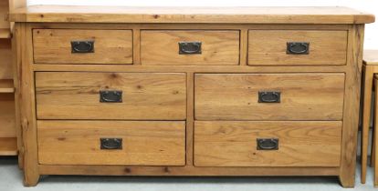 A contemporary elm bank of drawers with three short over two pairs of long drawers on square