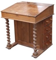 An early 20th century pine Davenport style desk with hinged top stationary compartment over hinged