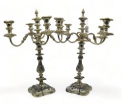 A pair of silver plated five light candelabra, with knopped stems, with cast scrolling foliate