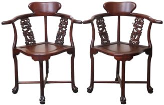 A pair of 20th century Oriental hardwood corner chairs with pierced splats carved with dragons