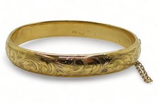 A 9ct gold hand engraved hollow bangle, inner diameter 6cm, weight 12.1gms Condition Report: