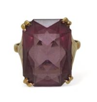 A 9ct gold ring set with a large purple gem, in an Egyptian style setting, finger size P1/2,