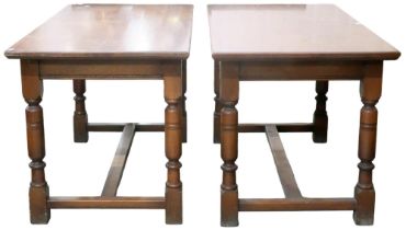 A pair of early 20th century oak library tables with rectangular tops on turned supports joined by