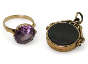 A yellow metal and faux amethyst ring, weight 4.0gms, together with a 9ct gold swivel seal, set with