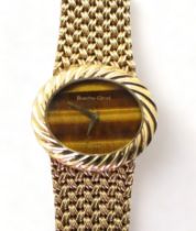 A BUECHE GIROD COCKTAIL WATCH mounted in 9ct gold with a herringbone patterned mesh strap and fluted