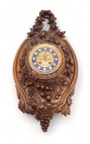 A 19TH CENTURY BLACK FOREST WALL CLOCK carved profusely with fruits, flowers and foliage, the gilded