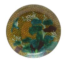 A JAPANESE CIRCULAR DISH Painted with a bird in flight above plantain on a cell pattern ground, 37cm