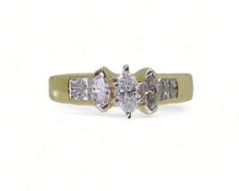 A 14CT GOLD DIAMOND CLUSTER RING set with three marquis cut diamonds and twelve princess cut