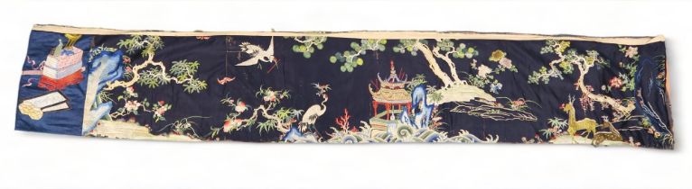 A CHINESE BLUE GROUND SILK EMBROIDERED PANEL depicting cranes and deer amongst peaches, pine