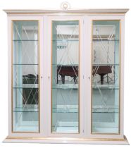 A CONTEMPORARY GILT WHITE VERSACE TRIPLE DOOR DISPLAY CABINET  with moulded cornice with laurel