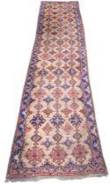 A LARGE BEIGE GROUND MALAYER RUNNER  with multicoloured medallions and geometric borders, 647cm long