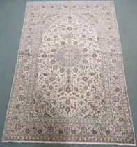 A CREAM GROUND KASHAN RUG with flower head central medallion, matching spandrels and flower head