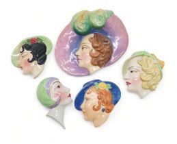 A COLLECTION OF ART DECO POTTERY WALL MASKS each modelled as a woman's head, many by C Ltd including