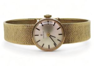 A LADIES 9CT TISSOT WRISTWATCH with integral patterned mesh strap, cream dial with baton numerals