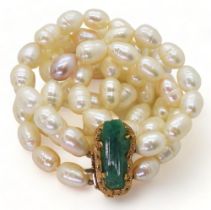 AN EMERALD AND PEARL NECKLACE the bright yellow metal clasp is set with a natural raw emerald