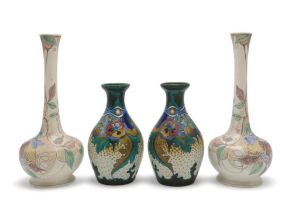 A PAIR OF GOUDA POTTERY VASES of bottle form painted with flowers and foliage, with painted marks