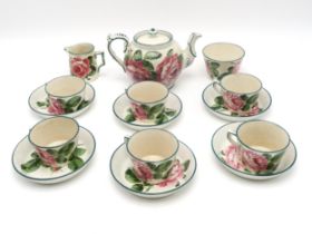 A WEMYSS WARE TEASET painted with cabbage roses, comprising teapot, six cups and saucers, milk jug