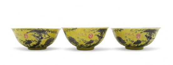 THREE CHINESE YELLOW GROUND BOWLS Painted with birds amongst scattered flowers and tendrils, gilt