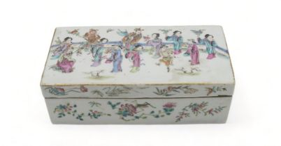 A CANTONESE RECTANGULAR PEN BOX Painted with figures within a fenced garden above insects and