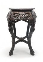 A CHINESE CARVED HARDWOOD MARBLE STAND the circular top above four openwork foliate carved aprons,
