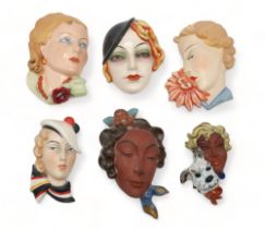 A COLLECTION OF CZECHOSLOVAKIAN ART DECO WALL MASKS all of girls' heads, including two terracotta