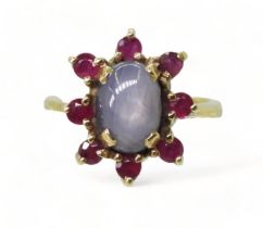 A RUBY AND STAR SAPPHIRE RING set in bright yellow metal stamped 750, the centre of the flower