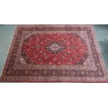 A RED GROUND KASHAN RUG  With dark blue and cream diamond central medallion and matching spandrels