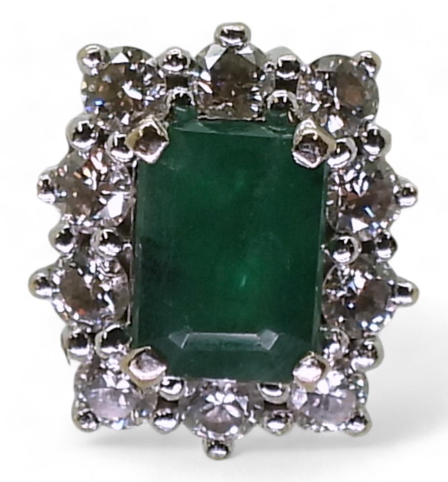 An 18ct white gold diamond and emerald cluster ring, finger size M1/2, weight 5.3gms