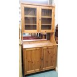 A contemporary pine Range style bookcase with pair of glazed doors over pair of cabinet doors, 199cm