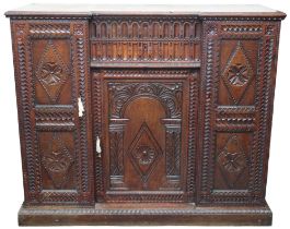 An early 20th century oak Jacobean style sideboard with two central drawers over single door flanked