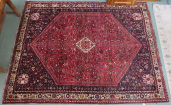 A red ground Qash'qai rug with cream geometric central medallion on geometric floral ground within